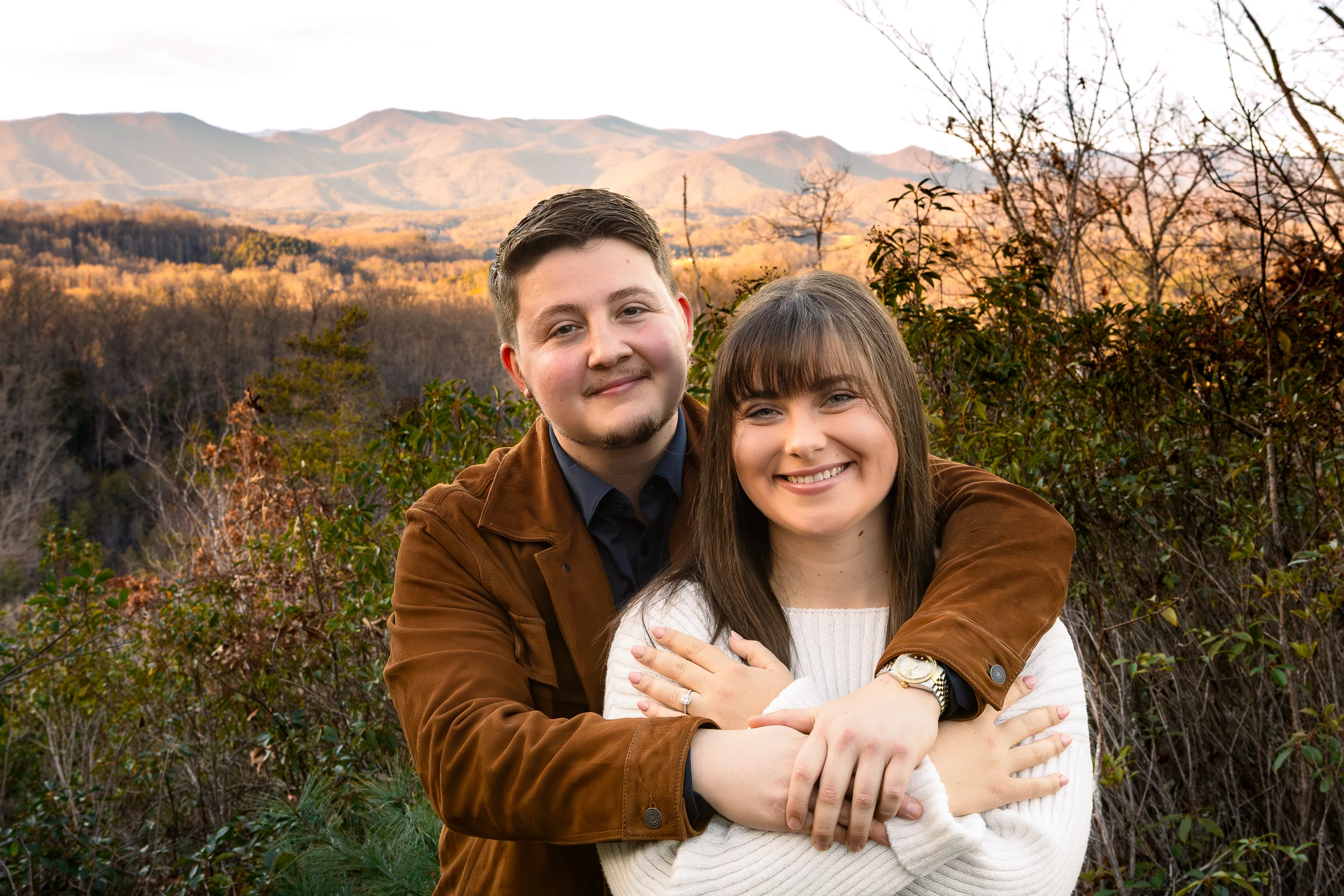 Gage and Riley smiling together in front of the Blue Ridge Mountains